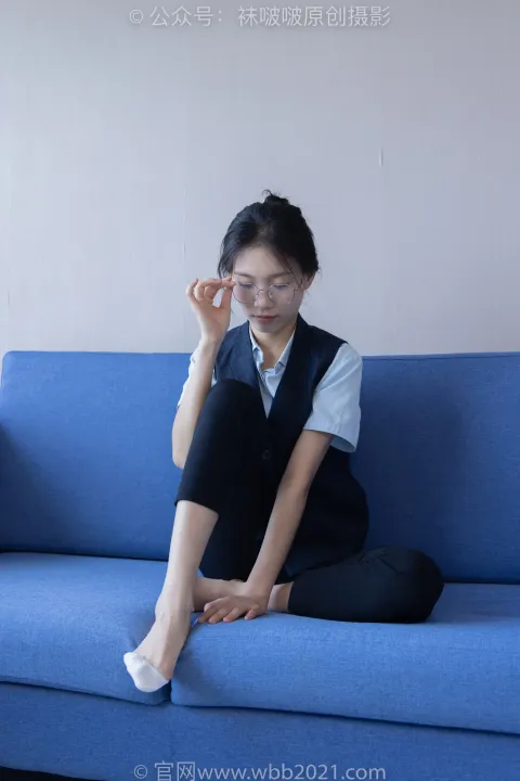 阿拉夫德女人坐在蓝色沙发上，双腿交叉