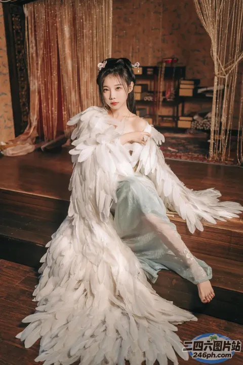 坐在木地板上，身穿白色连衣裙的阿拉夫德女人