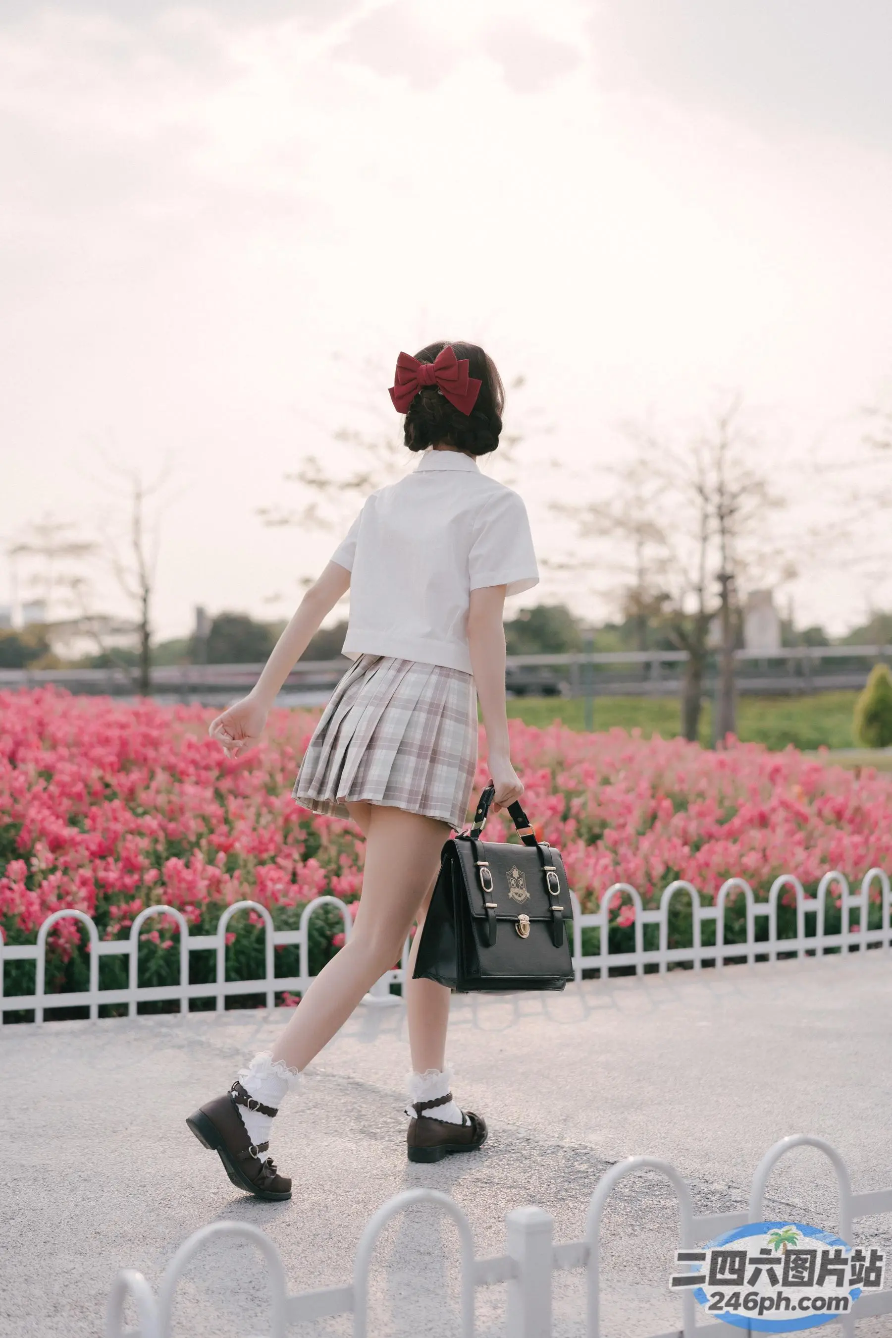 有一个女人提着一个钱包走在街上