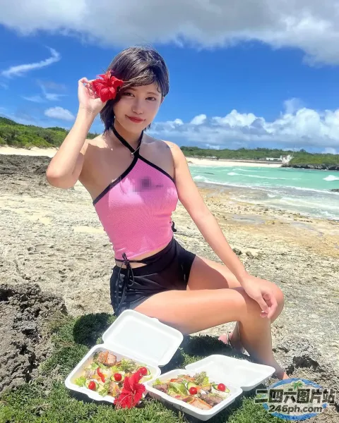 海滩上坐着一个女人，手里拿着一盘食物
