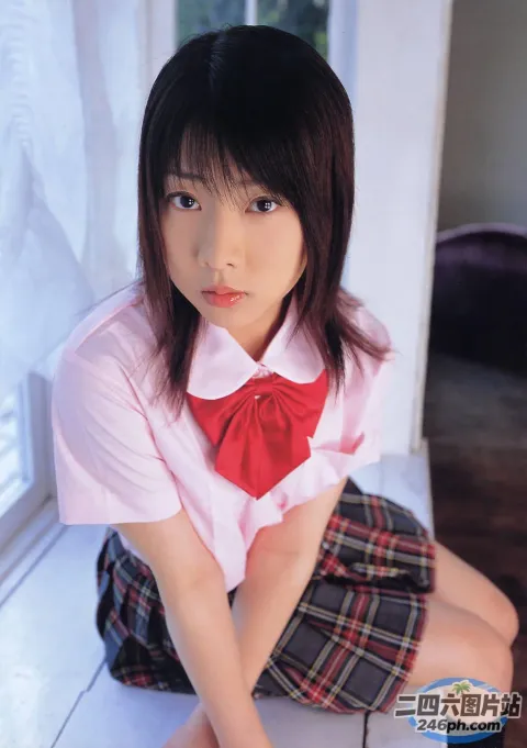 一位穿着校服的年轻女子坐在窗台上的特写