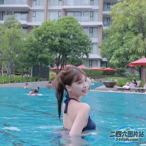 泳池里有个穿着比基尼的女人，背景是一栋建筑