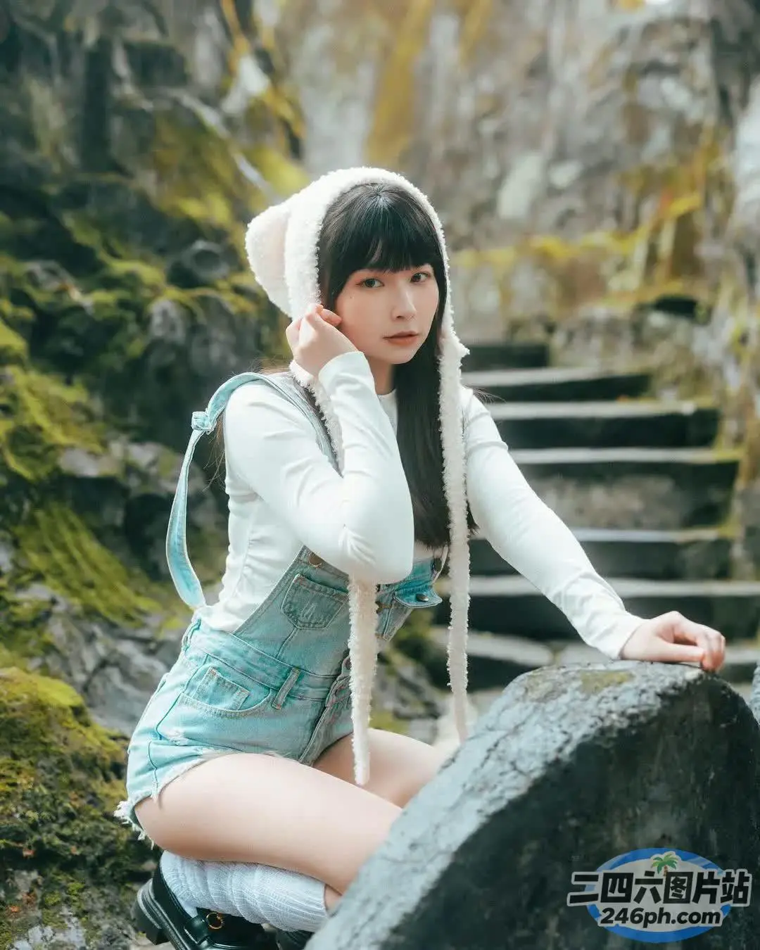一个女人坐在瀑布附近的岩石上的特写