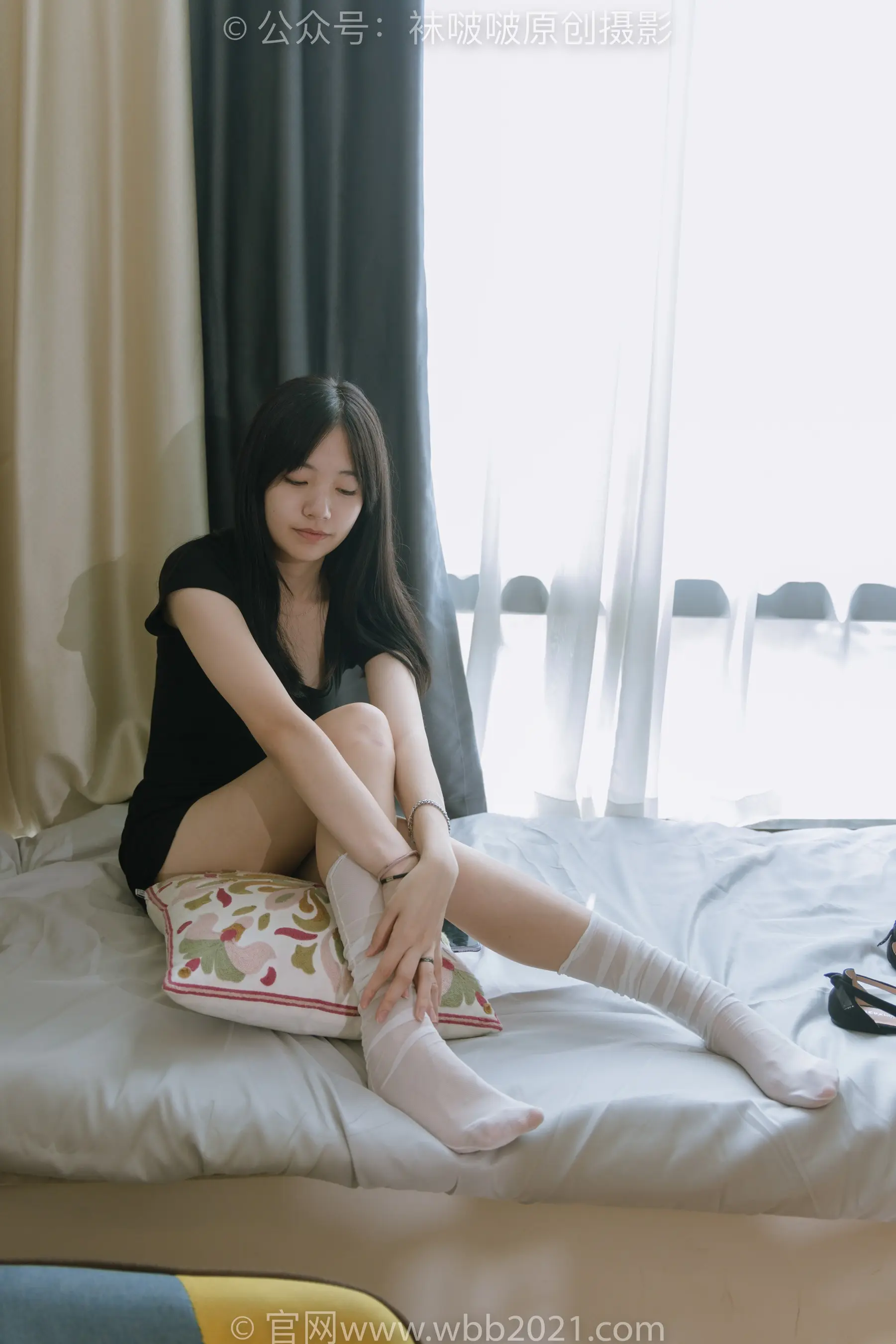 Araffe 坐在床上，拿着枕头和一双袜子