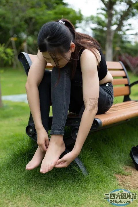阿拉菲女人坐在长凳上，双脚着地