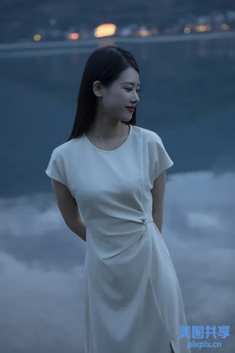 一个穿着白色连衣裙的女人站在海边的海滩上