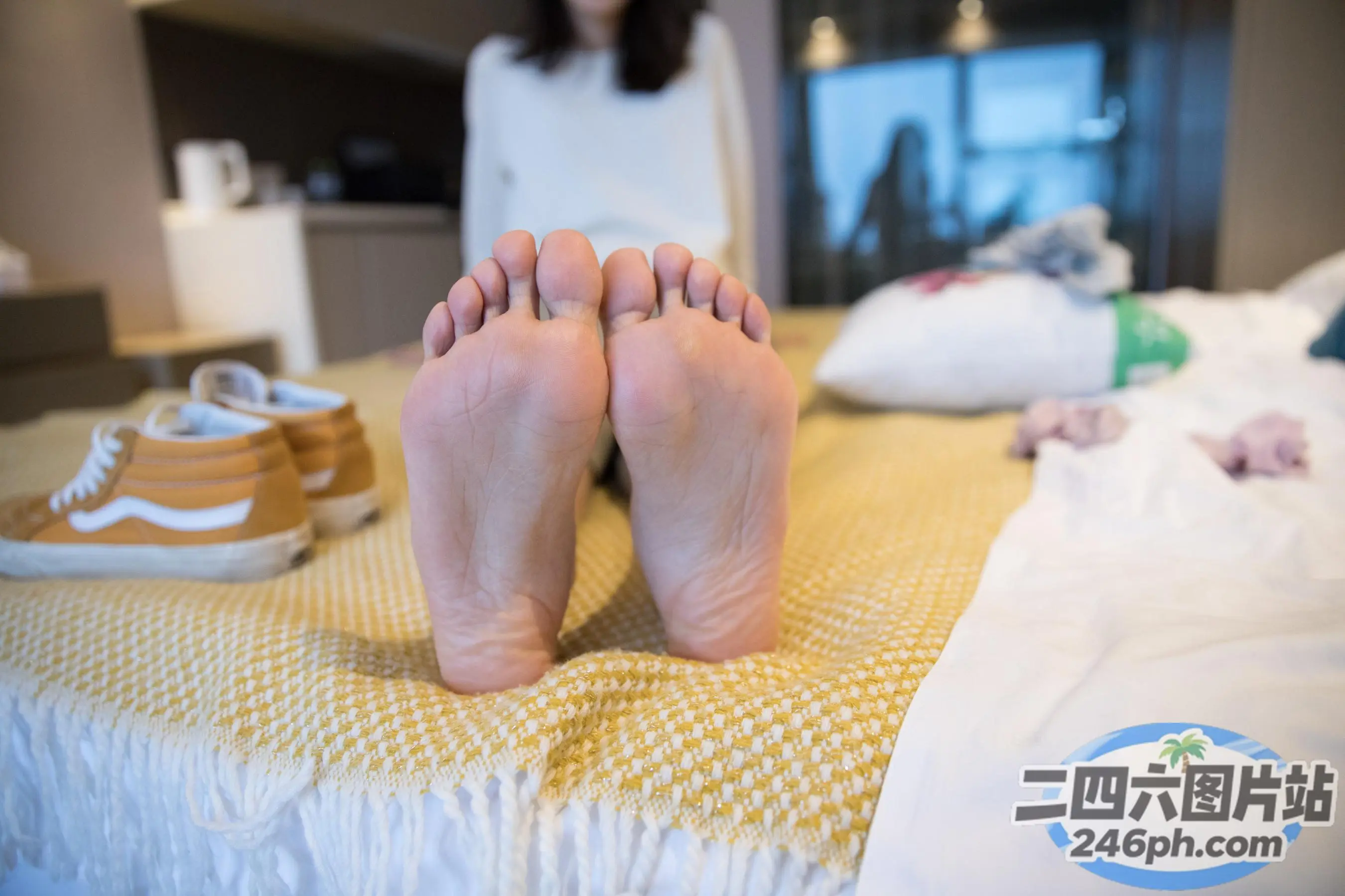 有人坐在床上，双脚抬起