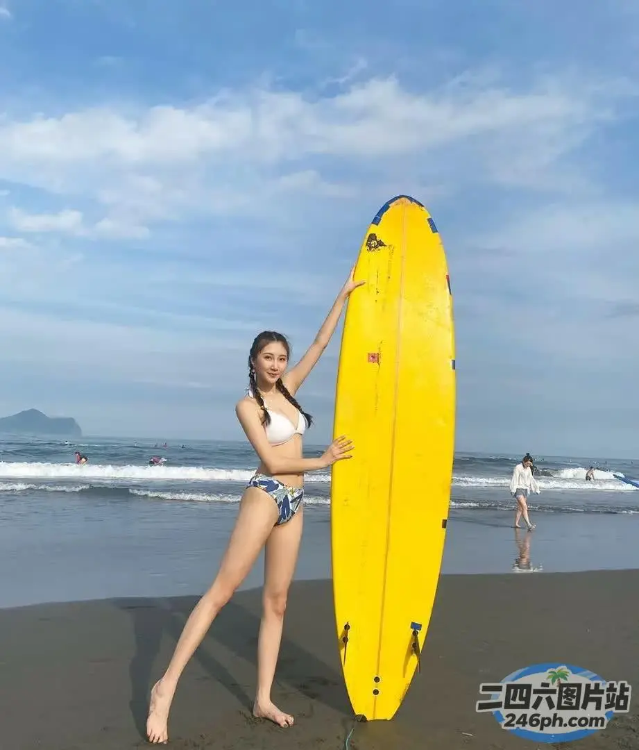 身穿比基尼的 Araffe 女子在海滩上举着黄色冲浪板