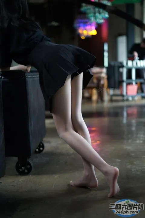 有一个女人拿着一个行李箱站在湿漉漉的地板上
