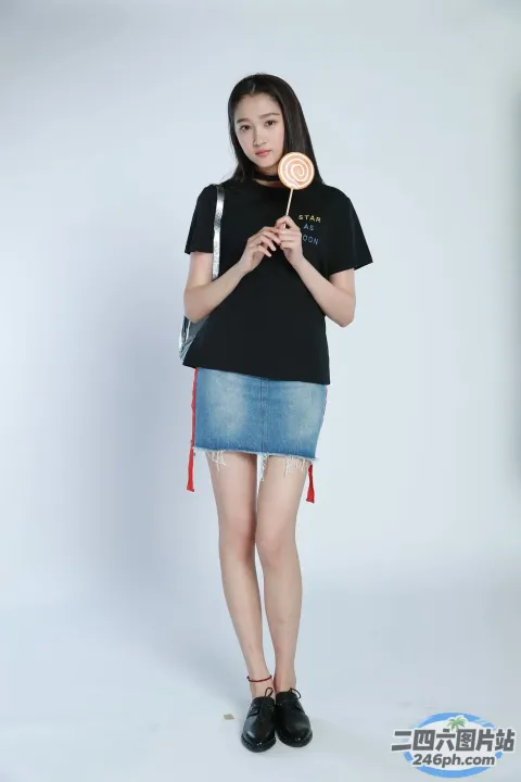 身穿黑色衬衫和牛仔裙的阿拉夫女人拿着棒棒糖