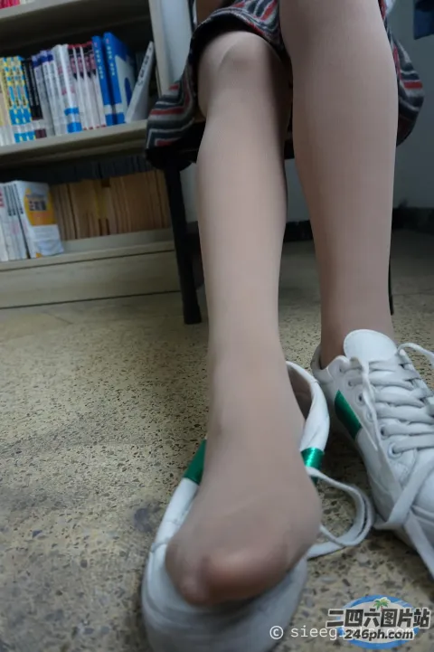 有人坐在椅子上，脚踩着一双鞋
