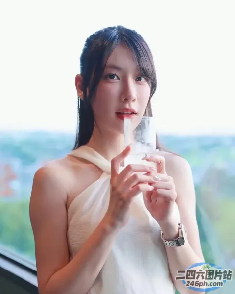 身穿白色连衣裙的阿拉菲女子，手里拿着一杯水