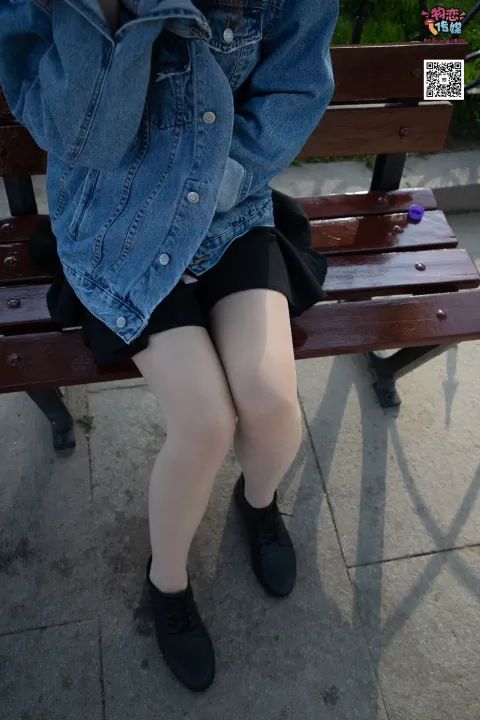 双腿交叉坐在长凳上的阿拉菲德女人