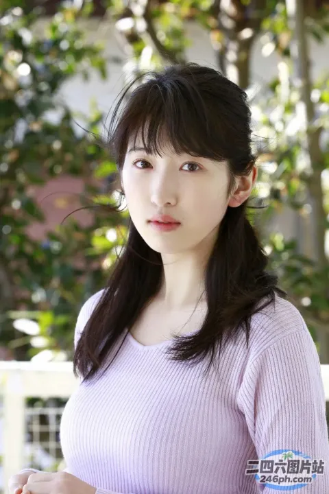 一个穿着粉红色衬衫和手机的女人的特写