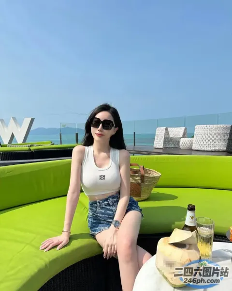 一个女人坐在绿色沙发上，手里拿着一瓶酒