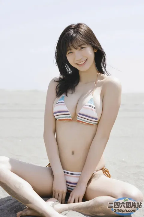 一名身穿比基尼的女子盘腿坐在海滩上