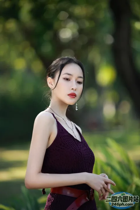 一个穿着紫色连衣裙的女人站在公园里