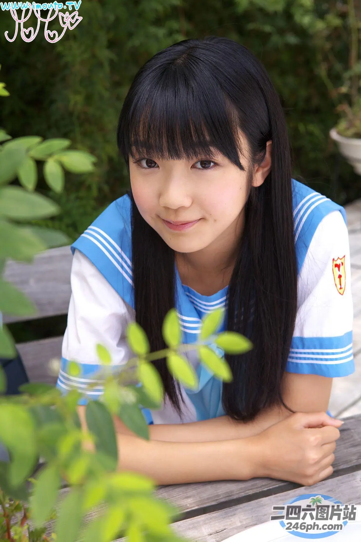 有一位年轻女子坐在长凳上，手里拿着一本书