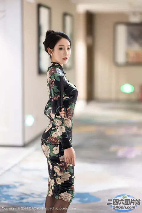 一个穿着碎花裙的女人站在走廊上