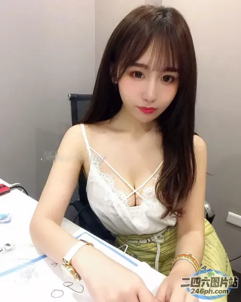 一个女人坐在桌子旁拿着一本书的特写