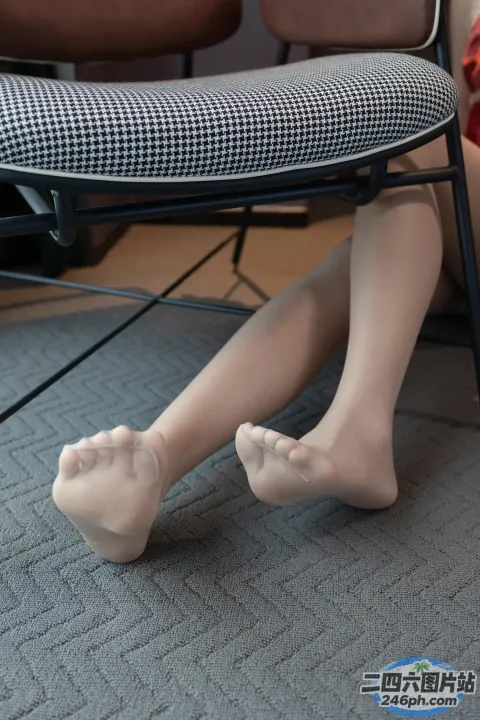 有个女人坐在椅子上，双腿交叉