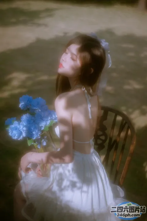 有一位女士坐在椅子上，手里拿着一束鲜花