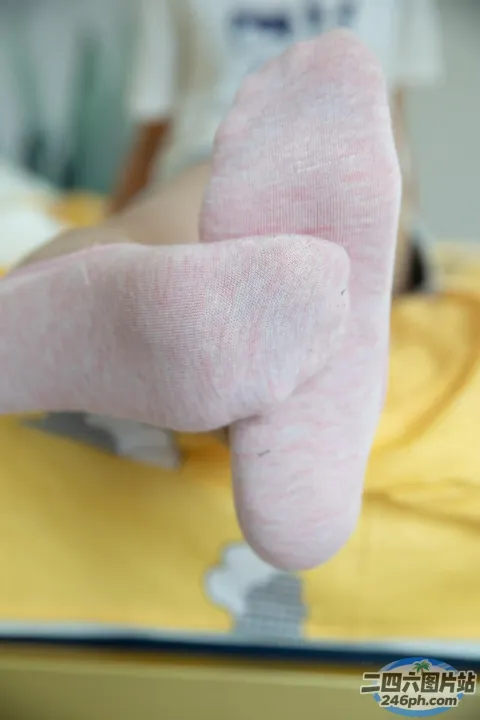 有人躺在床上，双脚抬起，穿着袜子
