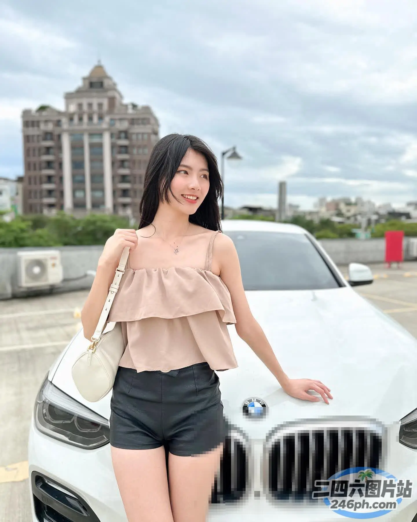 一名女子站在停车场的一辆白色宝马车旁
