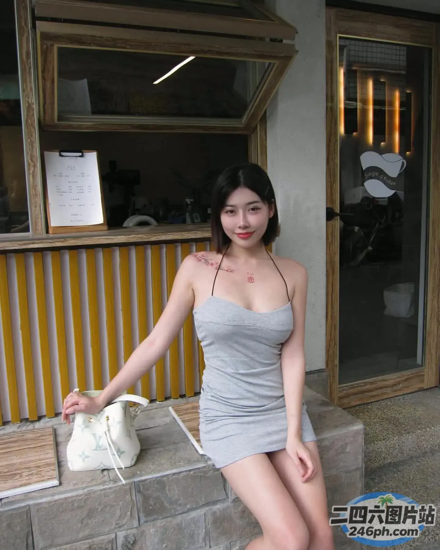 坐在石凳上穿着灰色连衣裙的 Araffe 女子