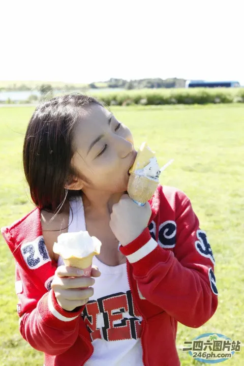 在田野里吃冰淇淋甜筒的 Araffe 女孩