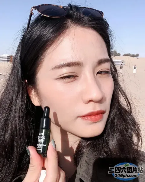 戴墨镜的女人拿着一瓶润唇膏
