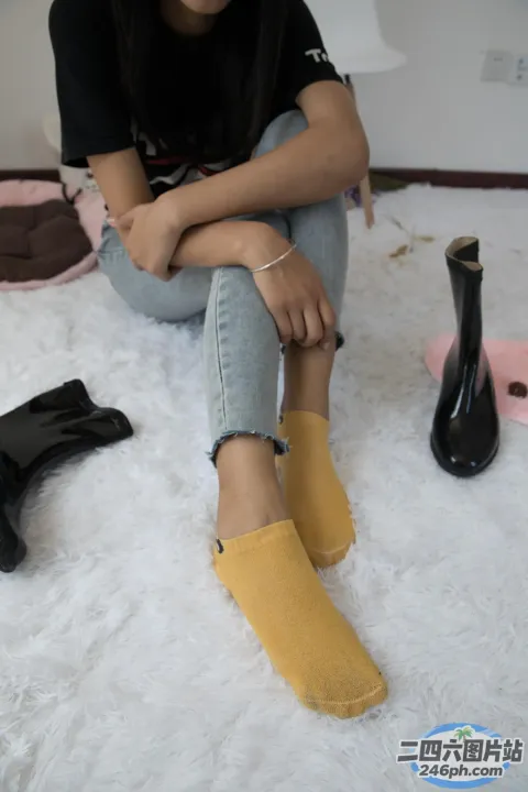 阿拉菲坐在白色地毯上，穿着一双鞋子和一双黑色靴子