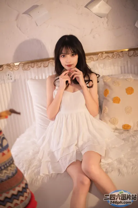 床上坐着一个穿着白色连衣裙的女人