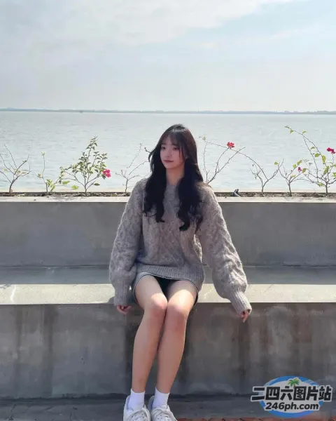 有个女人坐在水边的水泥长凳上