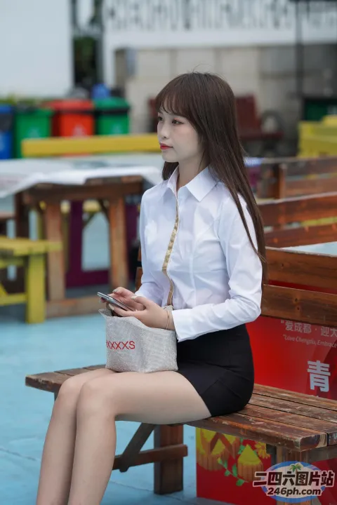 阿拉菲女子拿着包和手机坐在长凳上