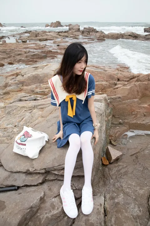 坐在海边岩石上的阿拉夫德女人