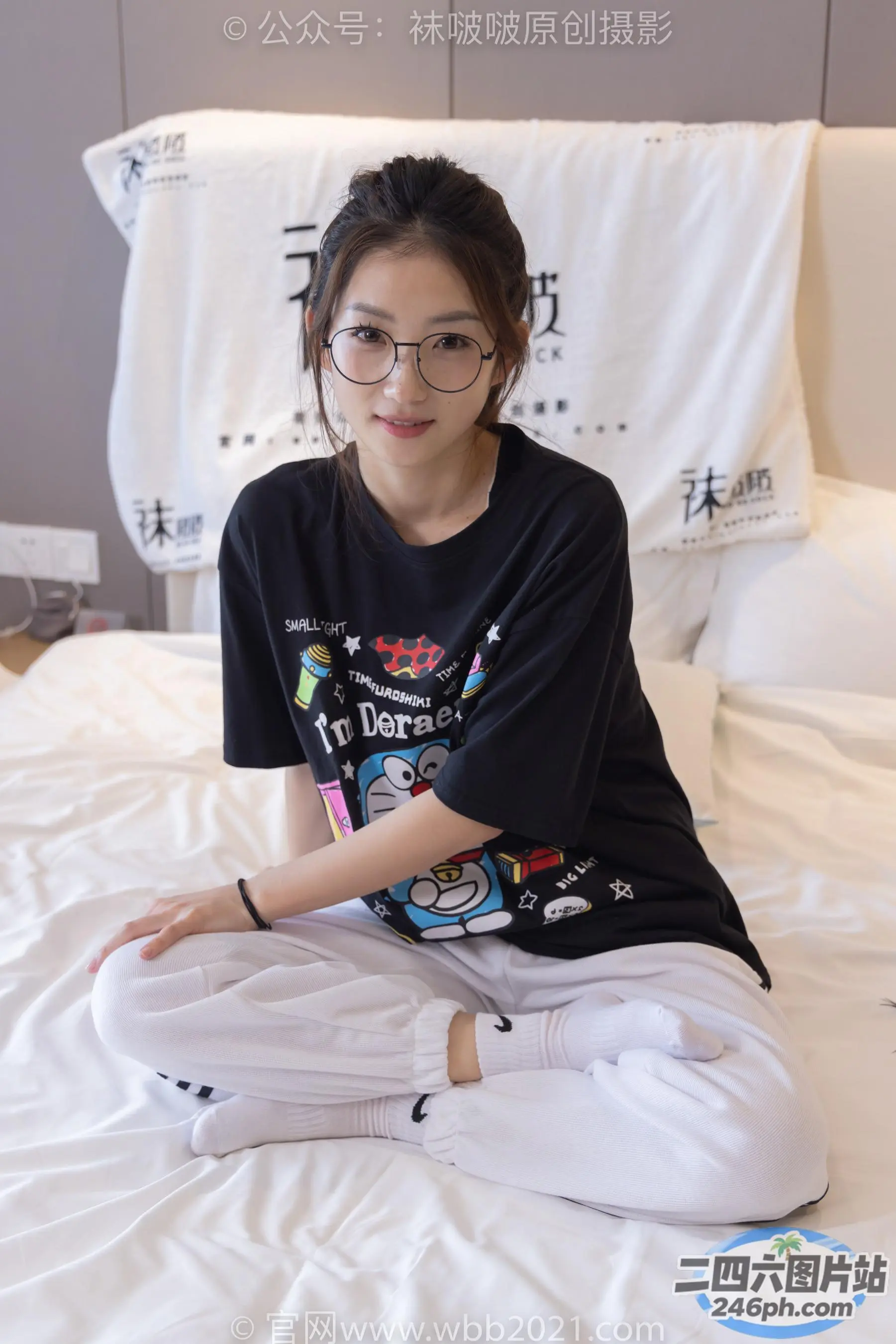 坐在床上的阿拉夫德女人，穿着黑色衬衫和白色裤子