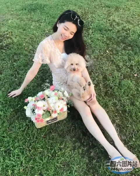 阿拉费德女人带着一只狗和一篮花坐在草地上