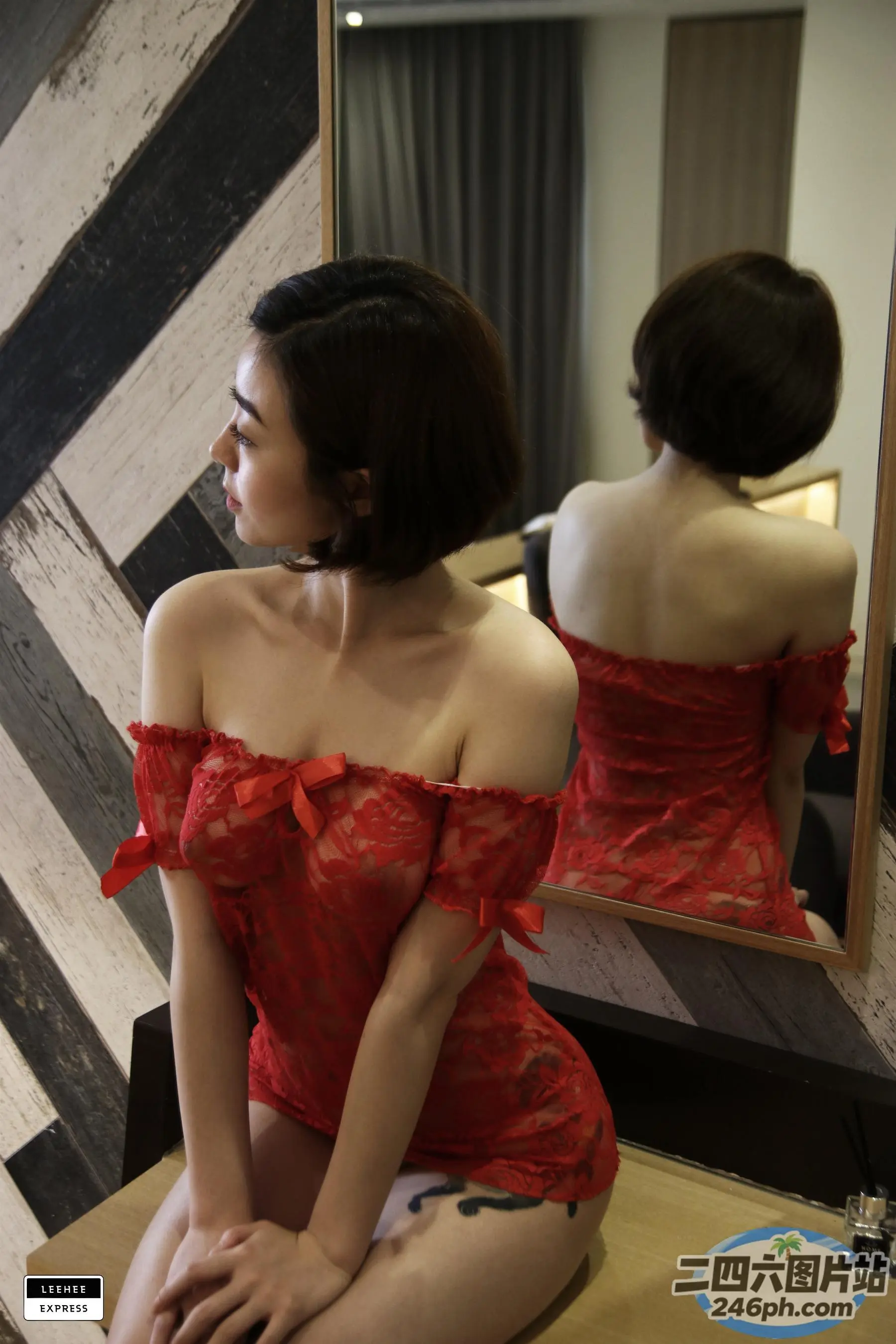 一位身穿红色连衣裙的女人坐在凳子上的特写