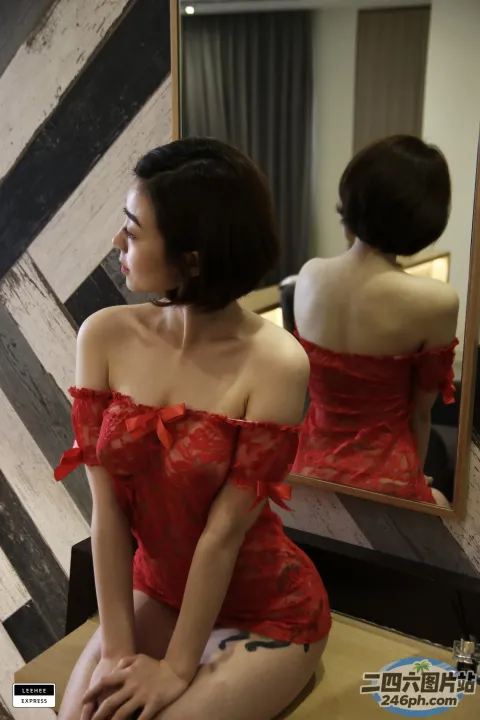 一位身穿红色连衣裙的女人坐在凳子上的特写