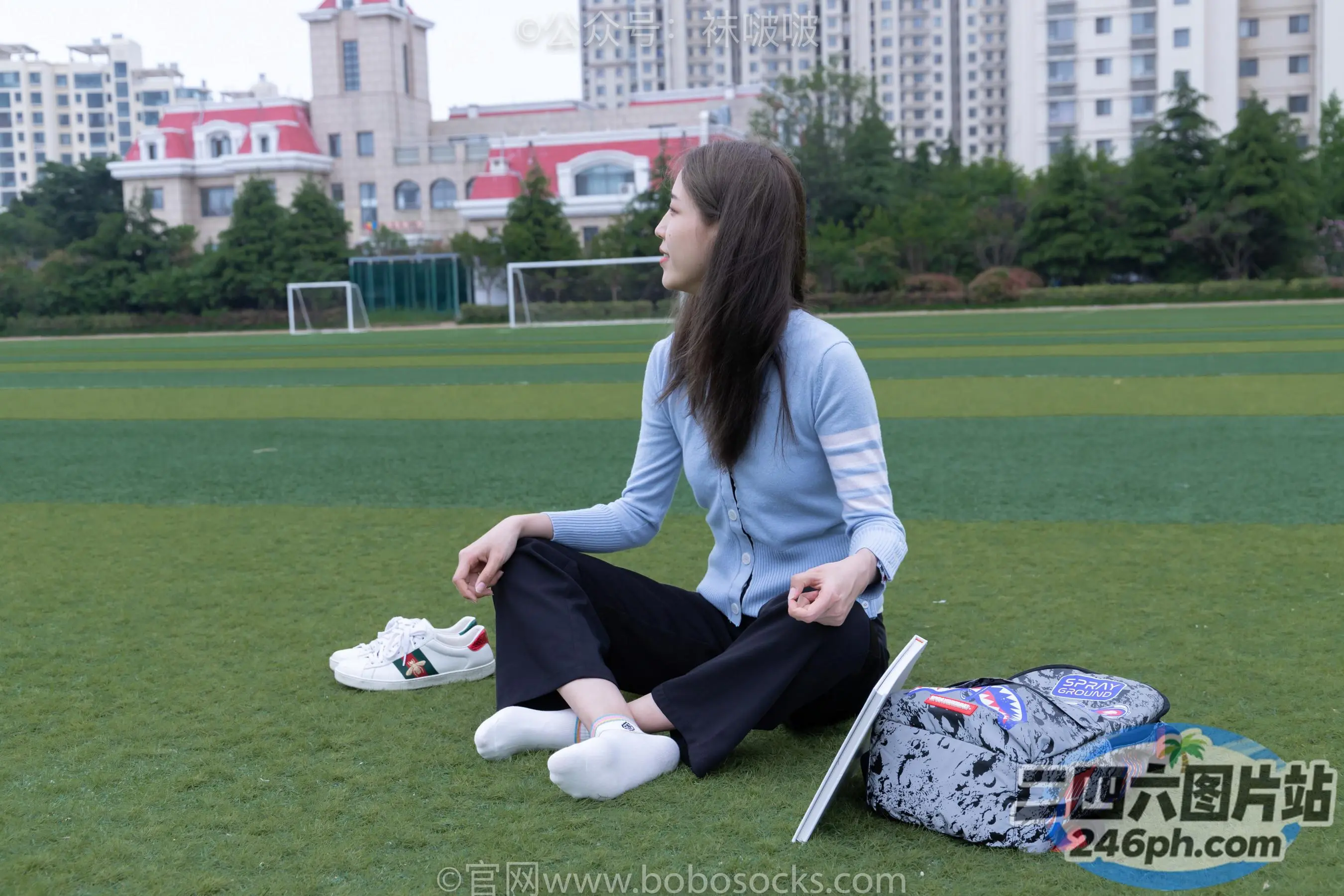 拿着笔记本电脑坐在草地上的阿拉菲德女人