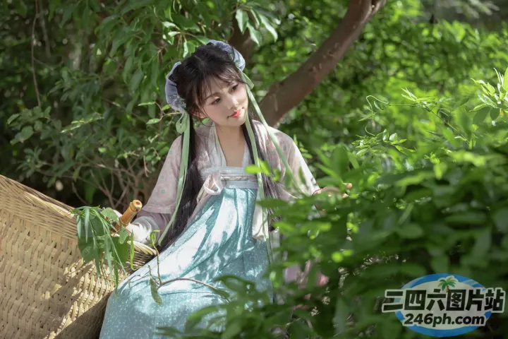 穿着蓝色连衣裙的阿拉夫德女人坐在花园的长椅上