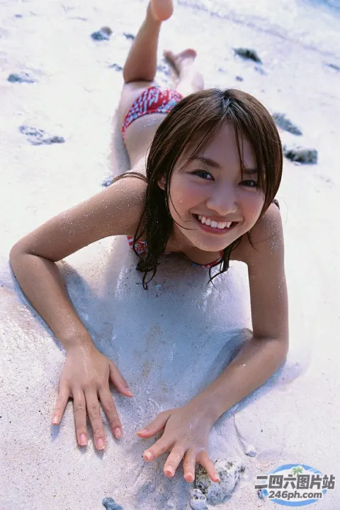 穿着比基尼的 arafed 亚洲女孩躺在海滩上的冲浪板上