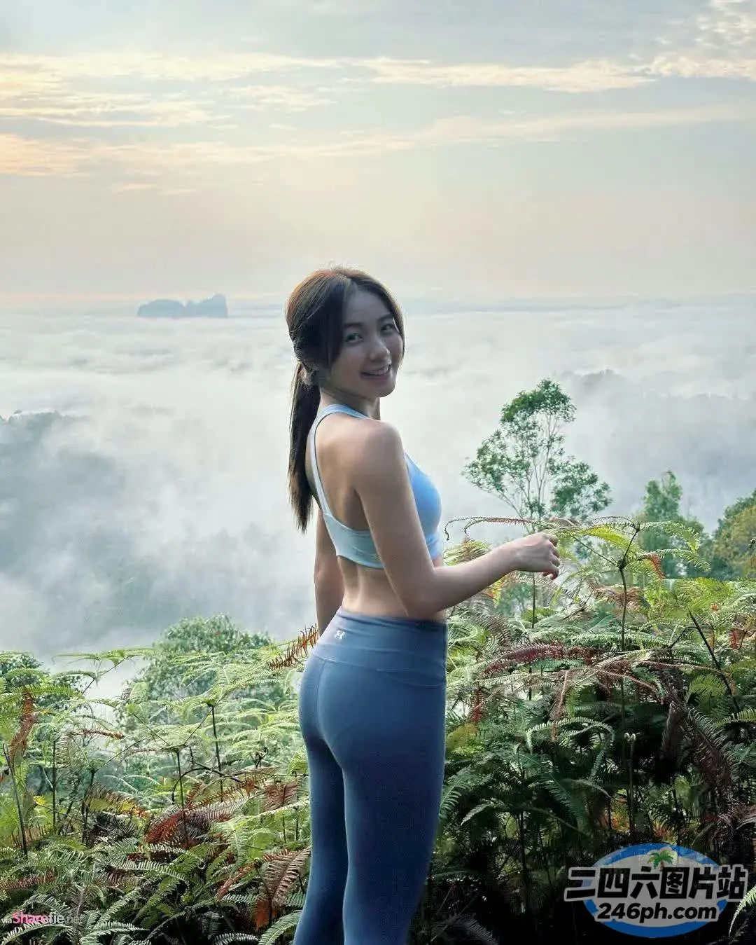 站在山顶上穿着蓝色紧身衣的 Arafed 女人