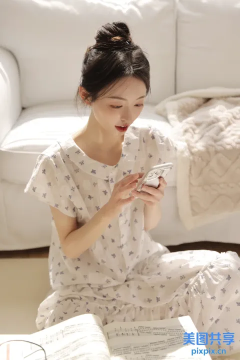 坐在地板上看手机的女人