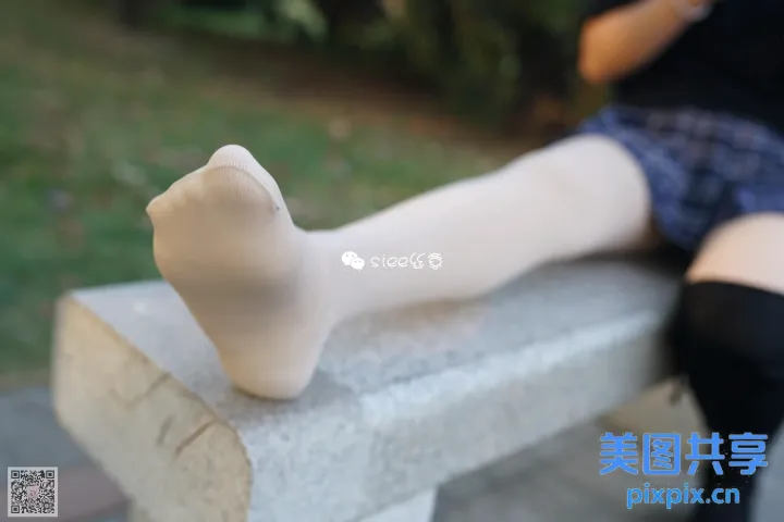有个女人坐在长凳上，双腿交叉