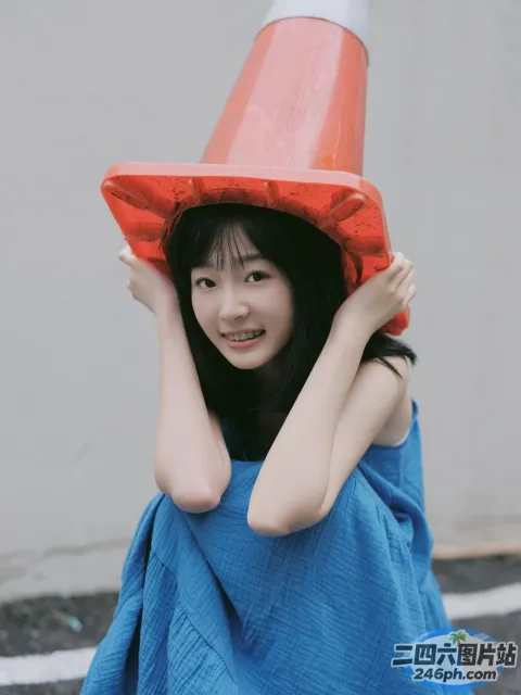一个穿着蓝色连衣裙、戴着红色帽子的女人