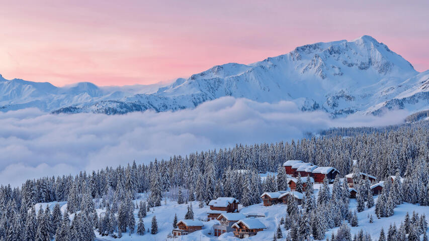 白雪皑皑的群山云彩，前景是一个小村庄