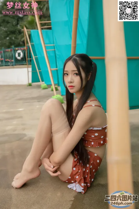 一个女人拿着网球坐在地上的特写