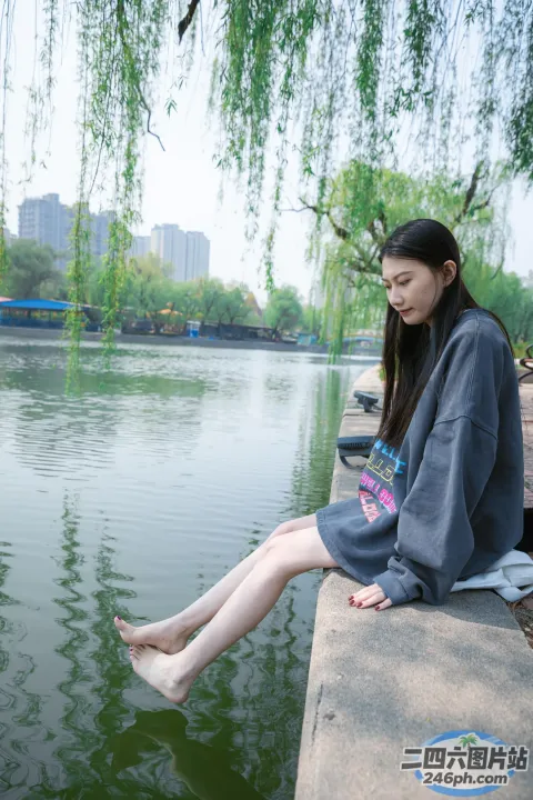 阿拉菲 （Araffe） 双腿交叉坐在水边的窗台上